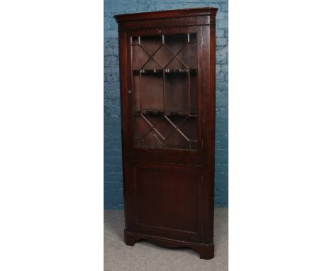 A Victorian mahogany corner cabinet, with astragal glazed panel and hinged lower drawer. Height: 186cm, Width: 81cm, Depth: 3