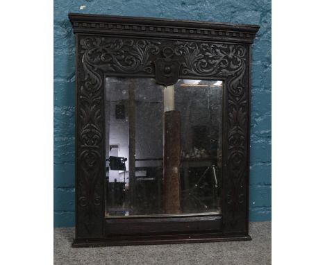 A Victorian bevel edged mirrored panel, with carved foliate surround and central thistle crest. Height: 70cm, Width: 57cm.  