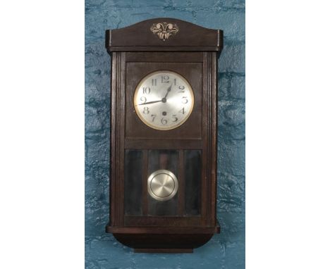 A carved mahogany wall clock with silvered dial.  