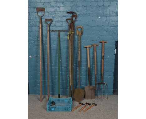An assortment of vintage garden tools and hammers. To include rake, hoes and forks etc.  Metal ware is rusting.