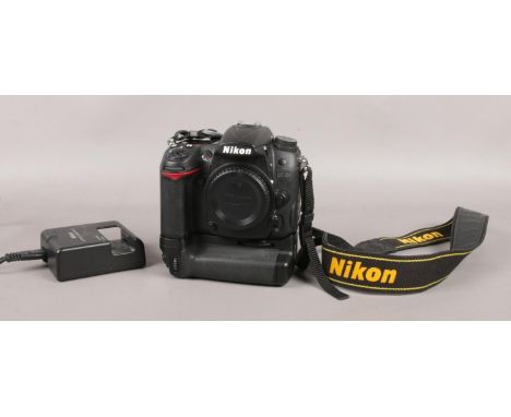 A Nikon D7000 SLR body camera with battery, charger and multi power battery pack.  Flash button missing.
