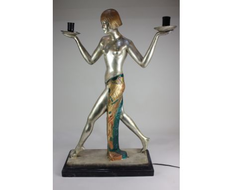 An Art Deco style chrome metal figural table lamp formed as a semi-nude dancer holding aloft two lights, with two globular gl