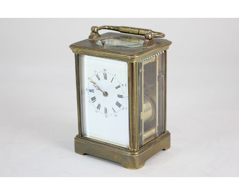 A brass and bevelled glass repeater carriage clock striking on a gong, the white enamel dial with Roman numerals, 18cm, with 