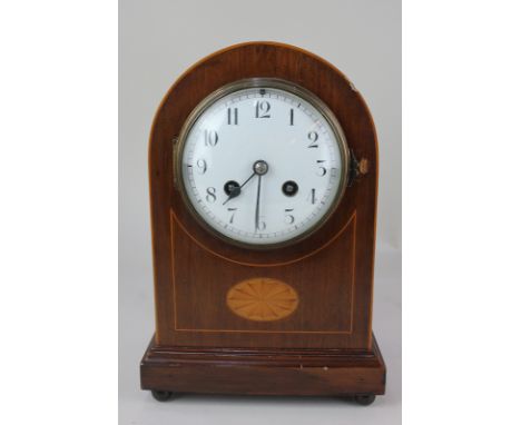 An Edwardian mahogany dome mantel clock the circular dial with Arabic numerals, the French movement half striking on a gong, 