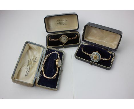 A 14ct gold and enamel wristwatch on a 9ct gold expanding bracelet, a 9ct gold bracelet watch by J W Benson, and another simi