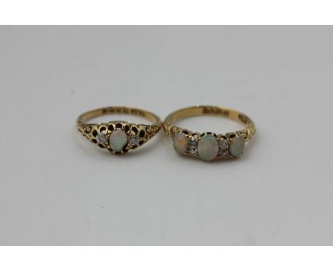 An opal and diamond ring set with three oval cut opals and old cut diamonds, and another smaller ring