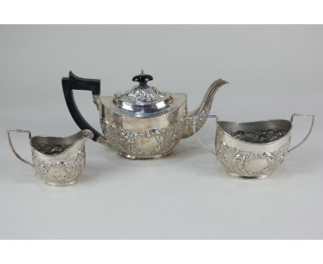 An Edward VII three piece breakfast tea set of teapot, sugar bowl and cream jug, oval shape, deeply embossed with scroll and 