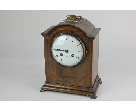 An Edwardian inlaid mahogany bracket mantel clock, domed top with brass handle, white enamel dial (a/f), striking on a gong, 