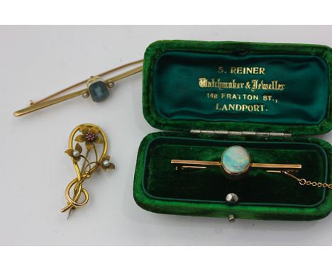 An opal bar brooch in fitted case, an aquamarine and seed pearl bar brooch, a pearl and ruby foliate brooch