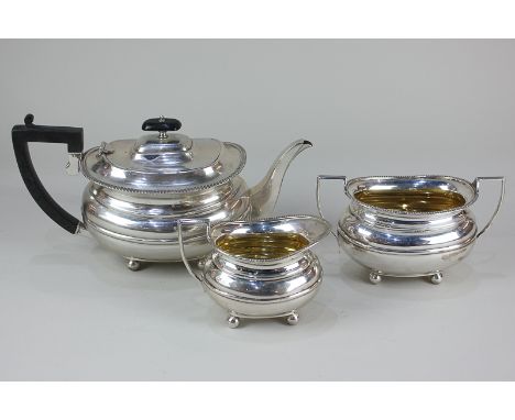 An Edward VII silver three-piece tea set of teapot, sugar bowl and cream jug, oval shape with gilt interior and gadrooned bor