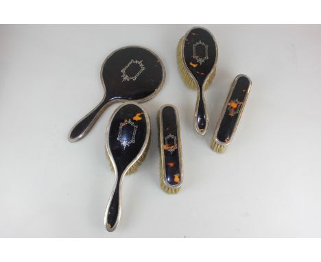 A George V silver and tortoiseshell dressing table set of two pairs of brushes and a hand mirror, maker Adie Brothers, Birmin