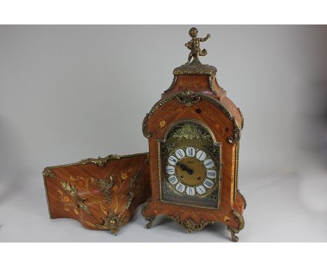A reproduction gilt mounted marquetry bracket clock in dome case with cherub surmount, on scroll feet with wall bracket, cloc