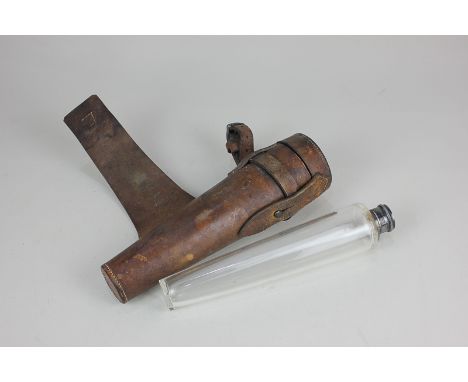 A silver plate lidded clear glass hunting flask in leather holder