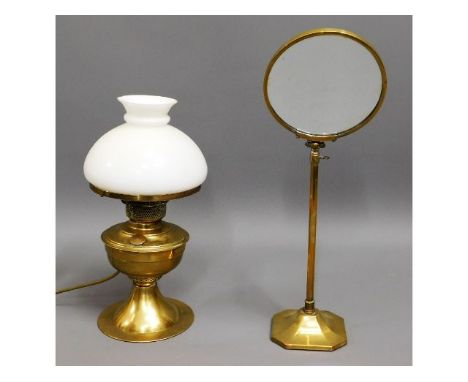 An early 20thC. brass shaving mirror twinned with a brass oil lamp converted to electricity