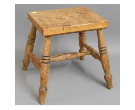 An early 20thC. oak stool with turned legs, 13.75in high