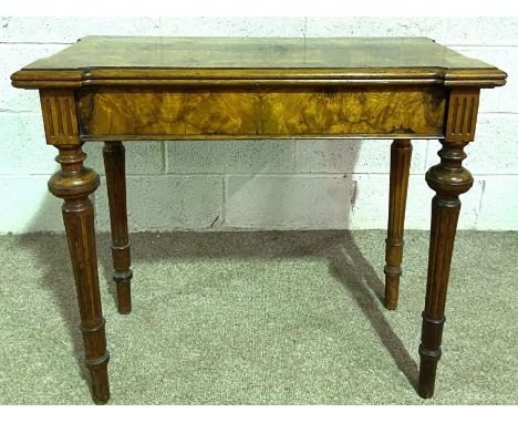 A Victorian walnut veneered card table, with a fold over top and turned and fluted legs, 78cm high, 91cm wide