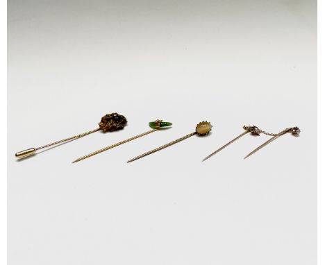 A gold nugget stick pin with 18ct gold pin sheath 6.1gm together with three other gold stick pins 2.8gm and a gilt stick pin 