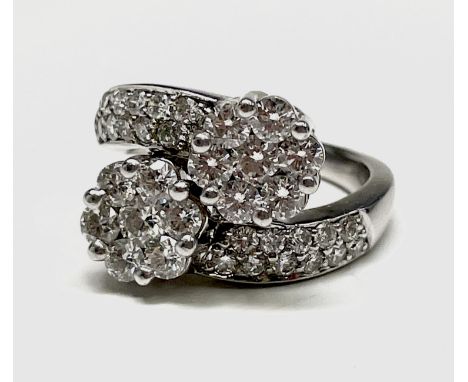 An 18ct white gold and diamond flowerhead crossover ring, 7.9g. Ring size O. Total diamond weight 2 carats. Condition: A litt