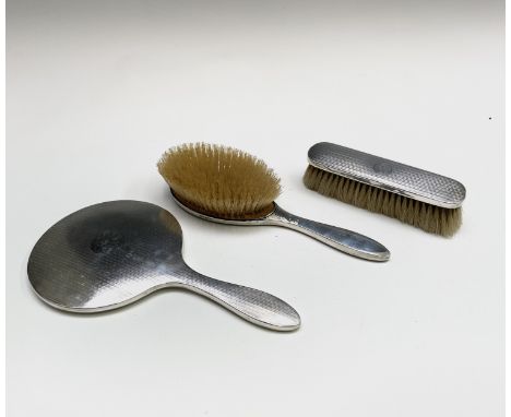 Two silver-mounted brushes and mirror - each engine turned and engraved with the letter A. Condition: In good used condition 