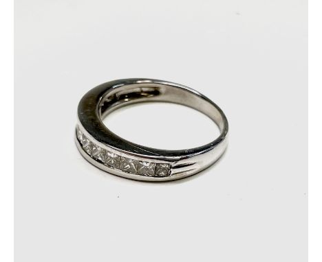 An 18ct white gold ring with a line of twelve calibre set diamonds. 4.6gm Condition: Signs of wear but no damage or condition