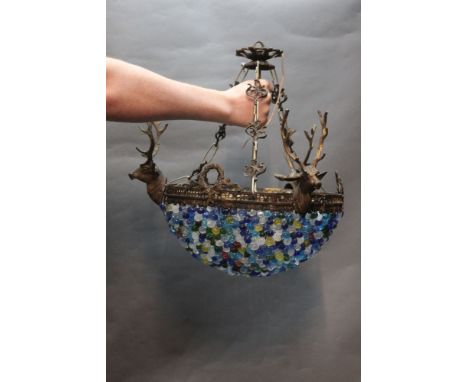 A ceiling light fitting with three stags heads above multicoloured glass dome.  Height +/- 46 cm. (527).