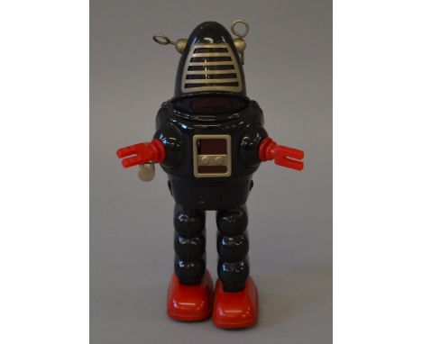 A vintage clockwork Robot of tinplate and plastic construction, marked 'Japan', approximately 22cm tall, with walking feature