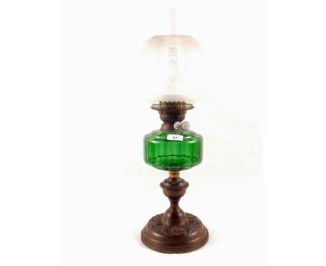 An embossed Brass oil lamp with green glass bowl and etched globe