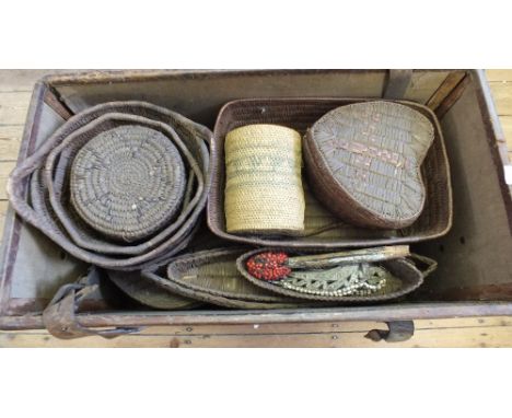 A leather trunk containing various vintage Canadian first settler basket work, Homalco Tribe,  including canoe shaped and oth