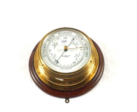A Brass barometer marked John Barker & Co Ltd, Kensington on wooden plaque