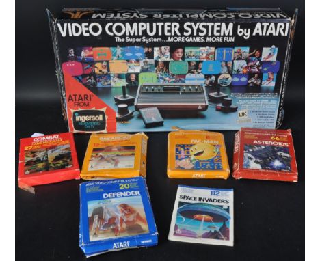 Retro Gaming - a boxed Atari 2600 video games console and five boxed games cartridges to comprise of; Defender, Pac-Man, Comb