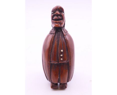 A carved coquilla nut figural snuff box. 8.5 cm high.