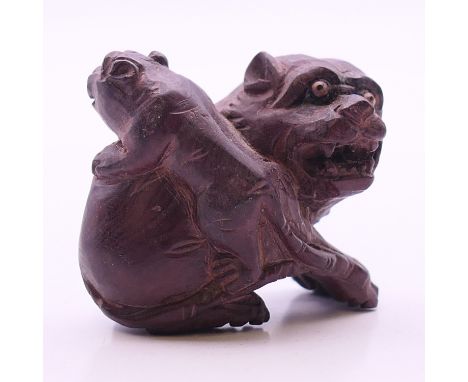 A netsuke formed as two dogs-of-fo.  3 cm high.