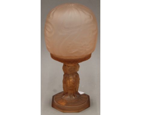 An Art Deco glass table lamp, the stem formed as putti. 29 cm high.