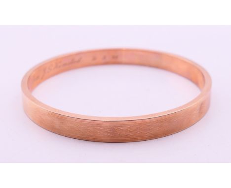 A 9 ct gold bangle, the inner band inscribed 'A token of appreciation from J G Hemsted 31.3.28'.  8.3 cm diameter, the band 3