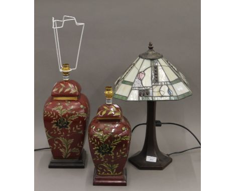 A pair of porcelain table lamps and a Tiffany-style table lamp. The latter 49 cm high.