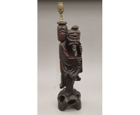 A late 19th/early 20th century Japanese carved hardwood lamp modelled as a fisherman. 57.5 cm high.