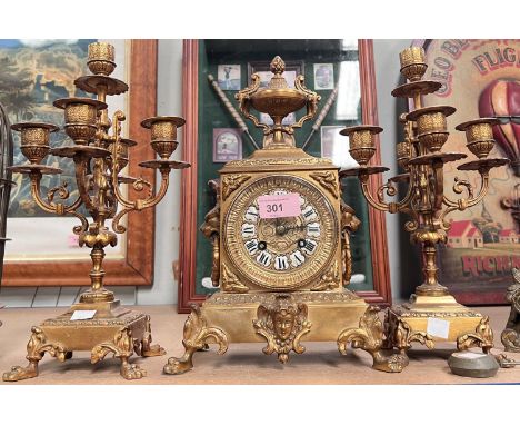 A Louis XVI style ormolu 3 piece clock garniture, the ornate clock with case finial and paw feet 