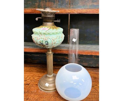 A Victorian opaque moulded green glass oil lamp on a gilt Corinthian column with a chimney and with a white globe shade. 