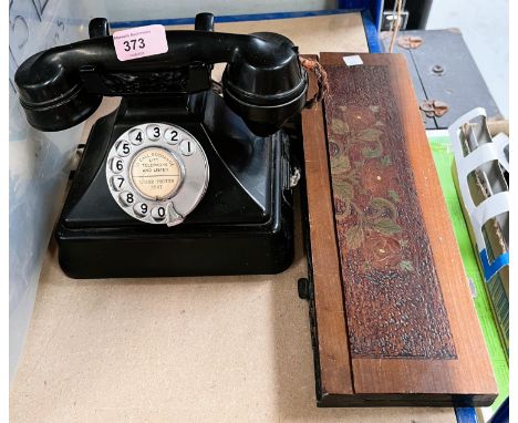 A vintage call exchange, black composition, rotary dial telephone and a poker work portable book shelf. 