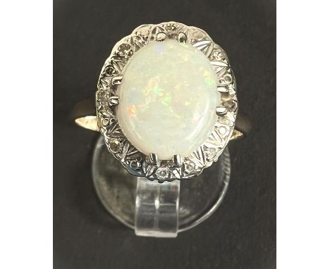 A 9ct hallmarked gold dress ring set with milky opal 12mm x 10mm with 4 small diamonds to sides, gross 3.9gm 