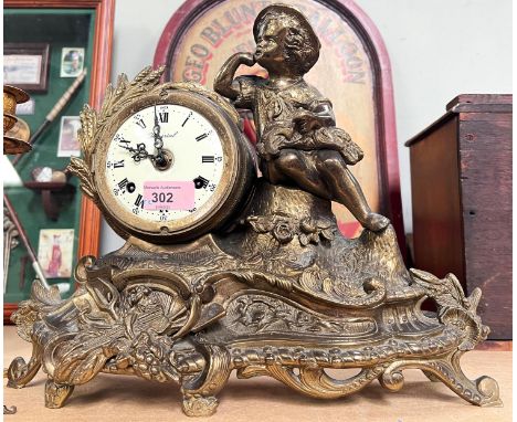 A French gilt metal mantle clock depicting a boy holding a wheatsheaf 