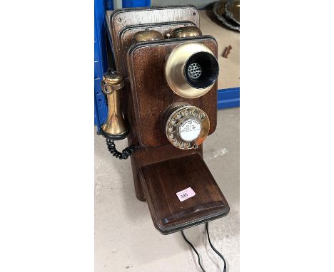 A wooden and brass vintage wall phone 