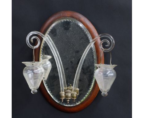 Venetian girandole oval mirror,&nbsp;the glass with an elliptical cut border, mounted on a wooden plaque, having two glass sc