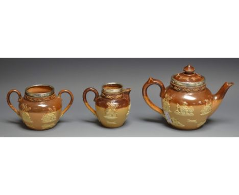A Doulton Lambeth salt glazed stoneware three piece tea service, sprigged with hunting scenes, silver mounted rims, London 18