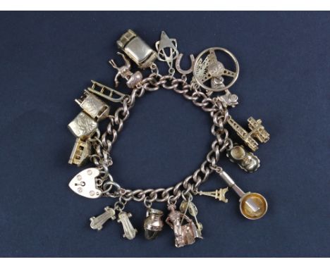 Charm bracelet (9ct) with approx 19 charms, includes Steering wheel, Car, roller skates etc. Weight approx 60g