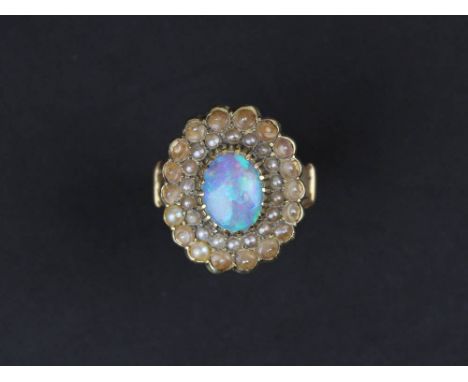 Yellow metal Ring set with large central Opal stone surrounded by seed pearls, size N weight 7grams