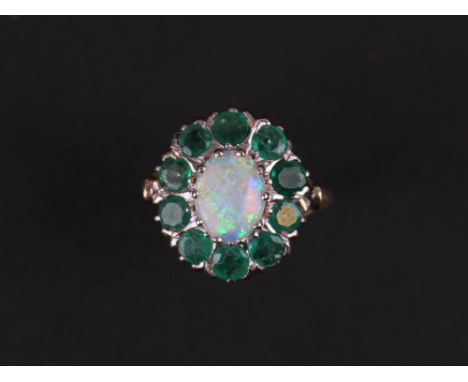 18ct Ring set with a central opal surrounded by 10 emeralds size N weight 5.0 grams