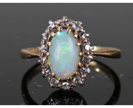 Yellow metal ring marked 18ct set with central opal surrounded by diamonds size K weight 2.8 grams