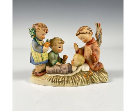 A matte hand painted figure depicting an angel visiting a new born baby while two children holding orange flowers curiously s