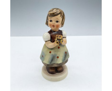 A matte and glossy figural of a sweet girl holding a bouquet of yellow flowers. M.I. Hummel impressed. Goebel backstamp. Incl